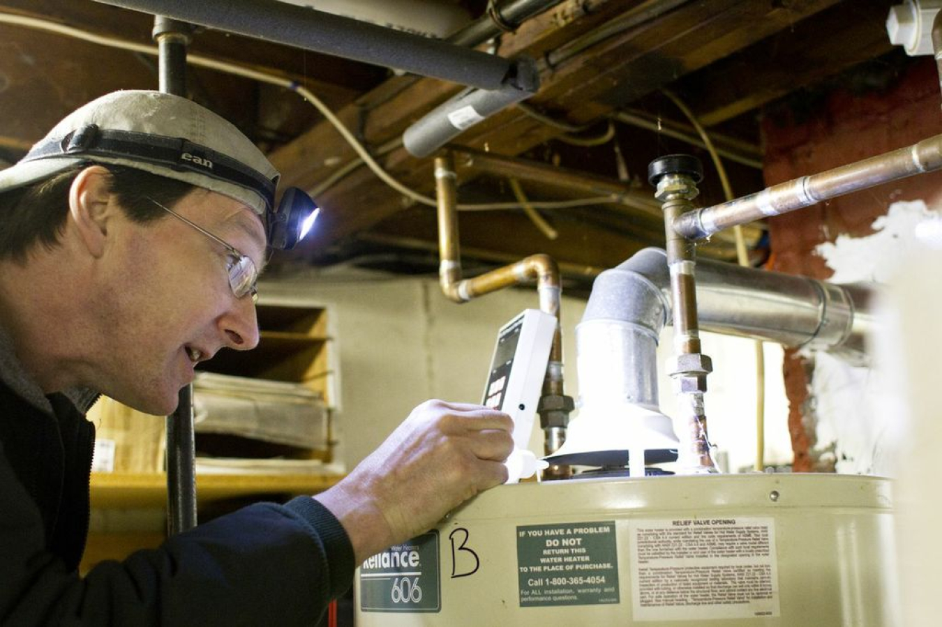 HVAC worker checking out a water heater.