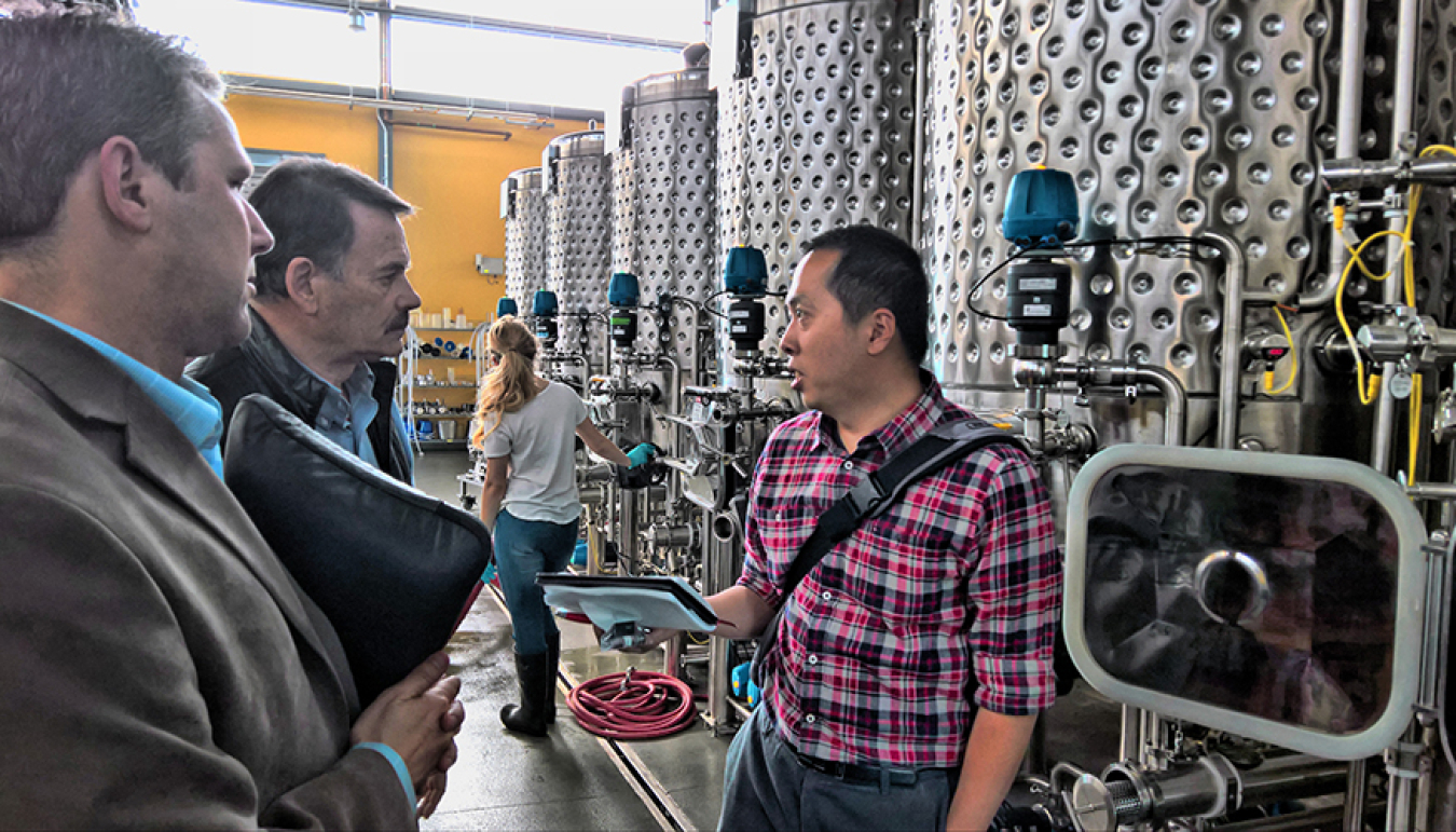 LLNL researcher Congwang Ye visits with professors at UC Davis to see their pilot-scale winery and brewery and learn about fermentation tank operations.