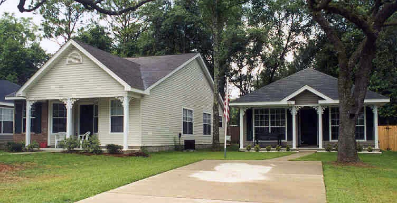 Photo of a house and garage with a driveway leading up to them.