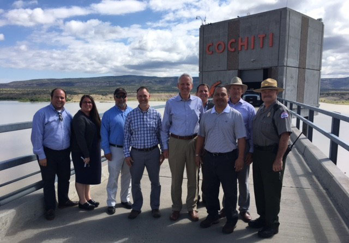 DOE representatives gather with Cochiti Pueblo Department of Natural Resources and Conservation Manager Jacob Pecos, third from right, and an Army Corps of Engineers employee, far right, at the Cochiti Dam.