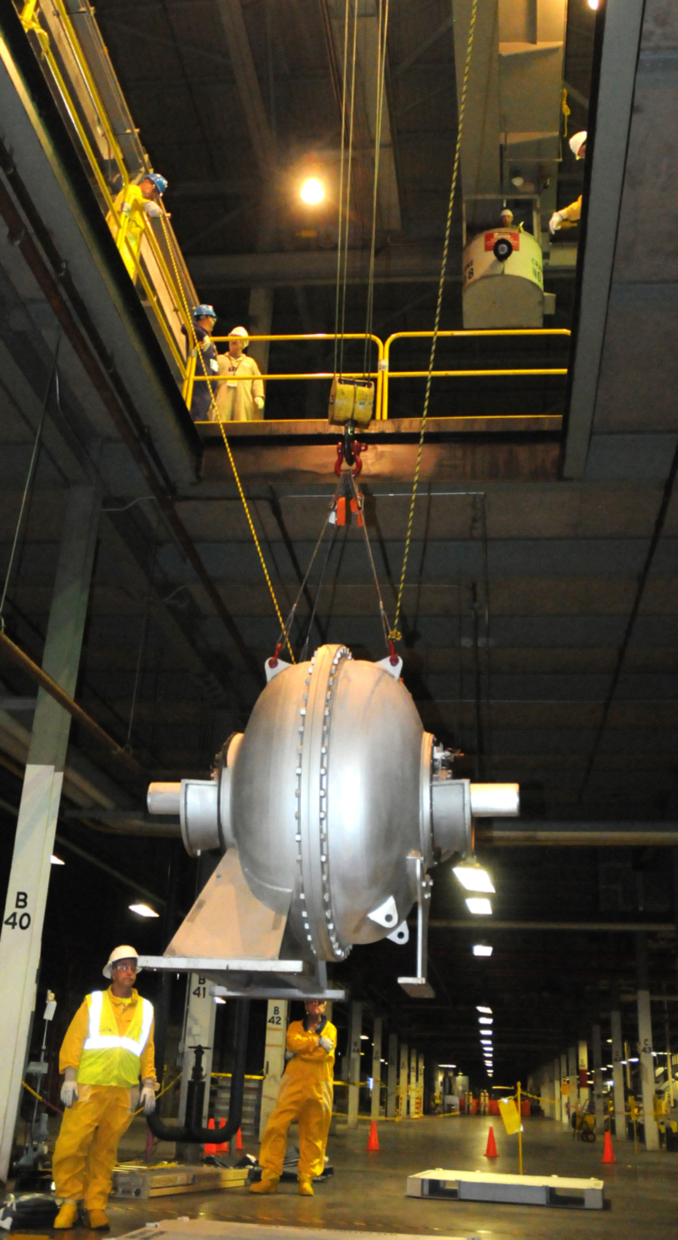 Decontamination and Decommissioning workers lower a large compressor from the second-floor to the first floor of the X-326 uranium enrichment process building at the Portsmouth Gaseous Diffusion Plant to be prepared for offsite shipment and disposition.