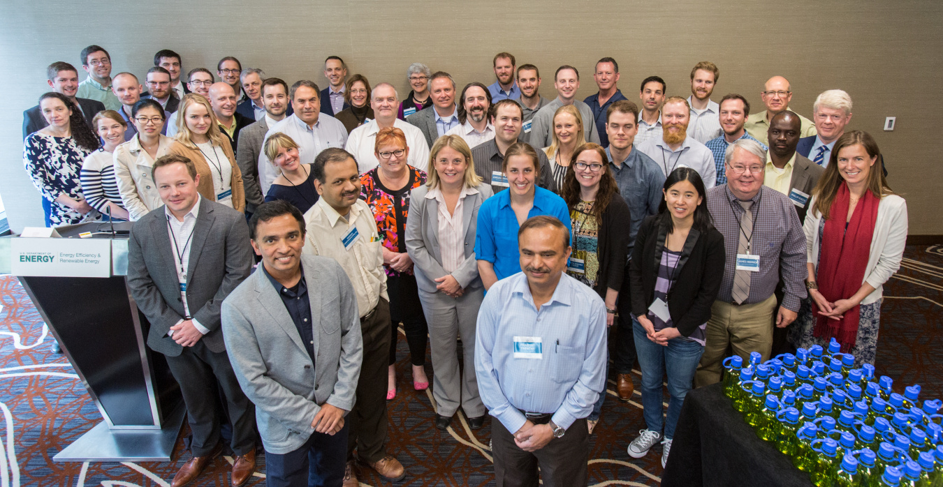 Group of people looking up towards the photographer standing in five rows.