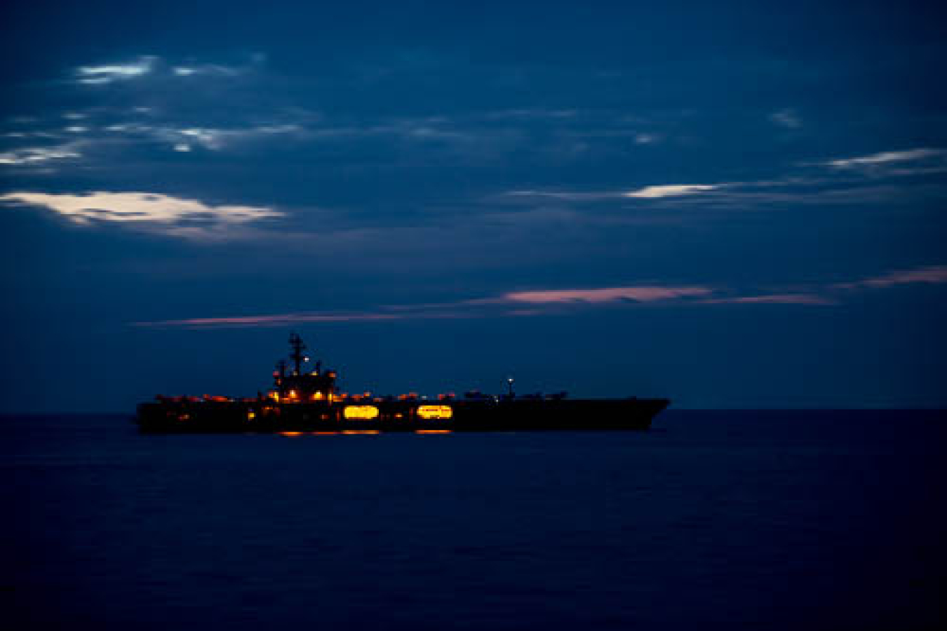 A U.S. Navy nuclear-powered aircraft carrier at night