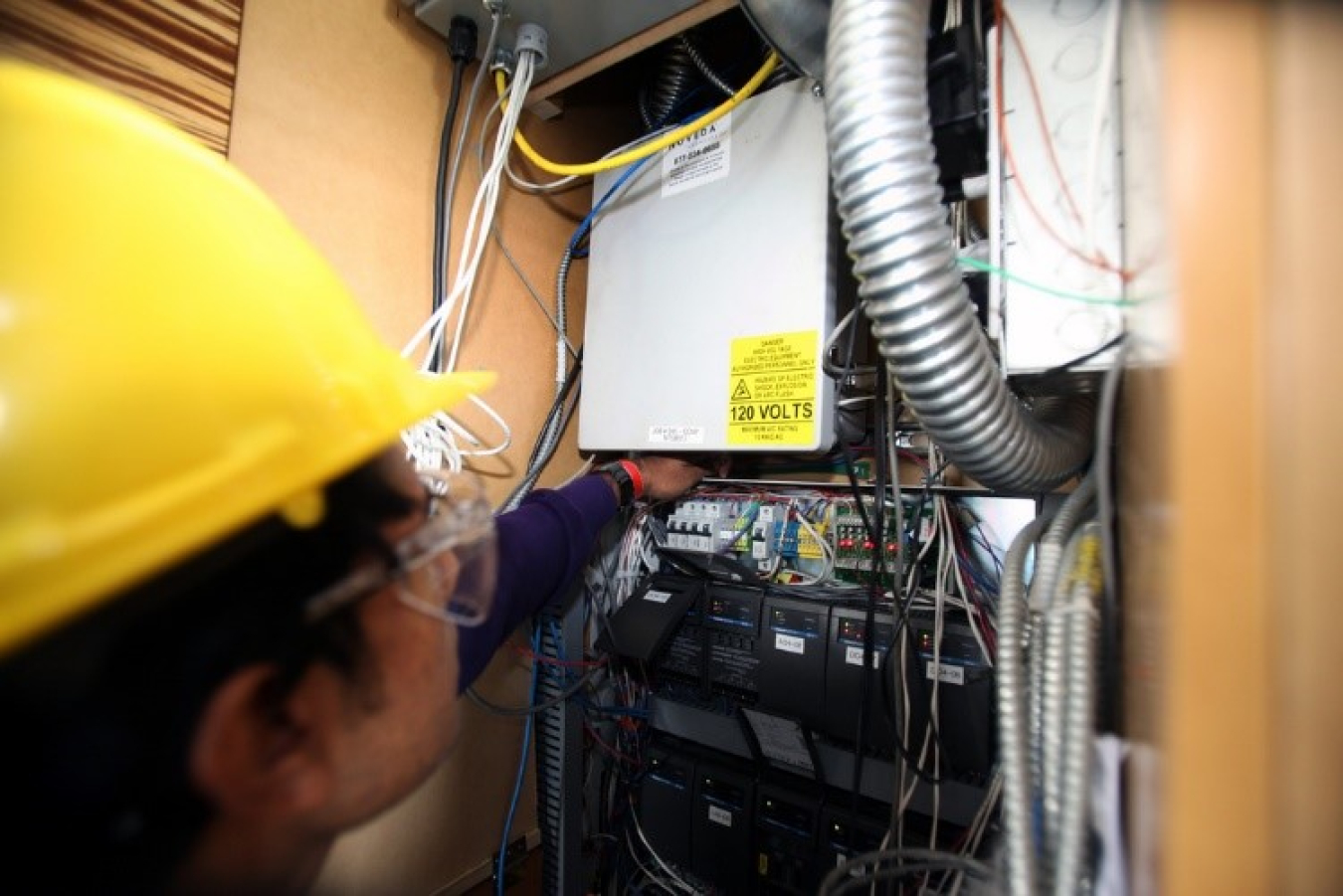 A worker looks to connect wires in a home.