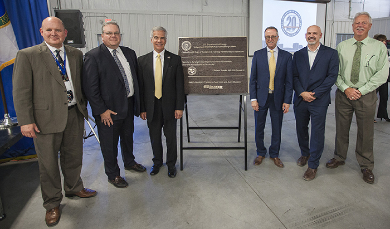 Paul Vandervert, Eric Dean, Glenn Podonsky, Dan Stepano, Bob Wilkinson and Gordon McCleary stand near a plaque unveiled for the celebration.