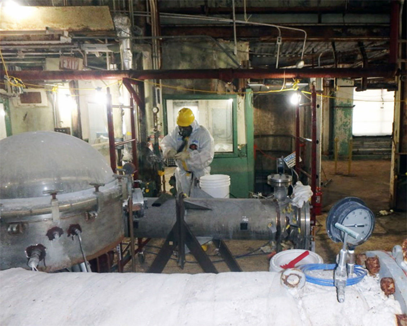 A worker removes asbestos from Building 7500.