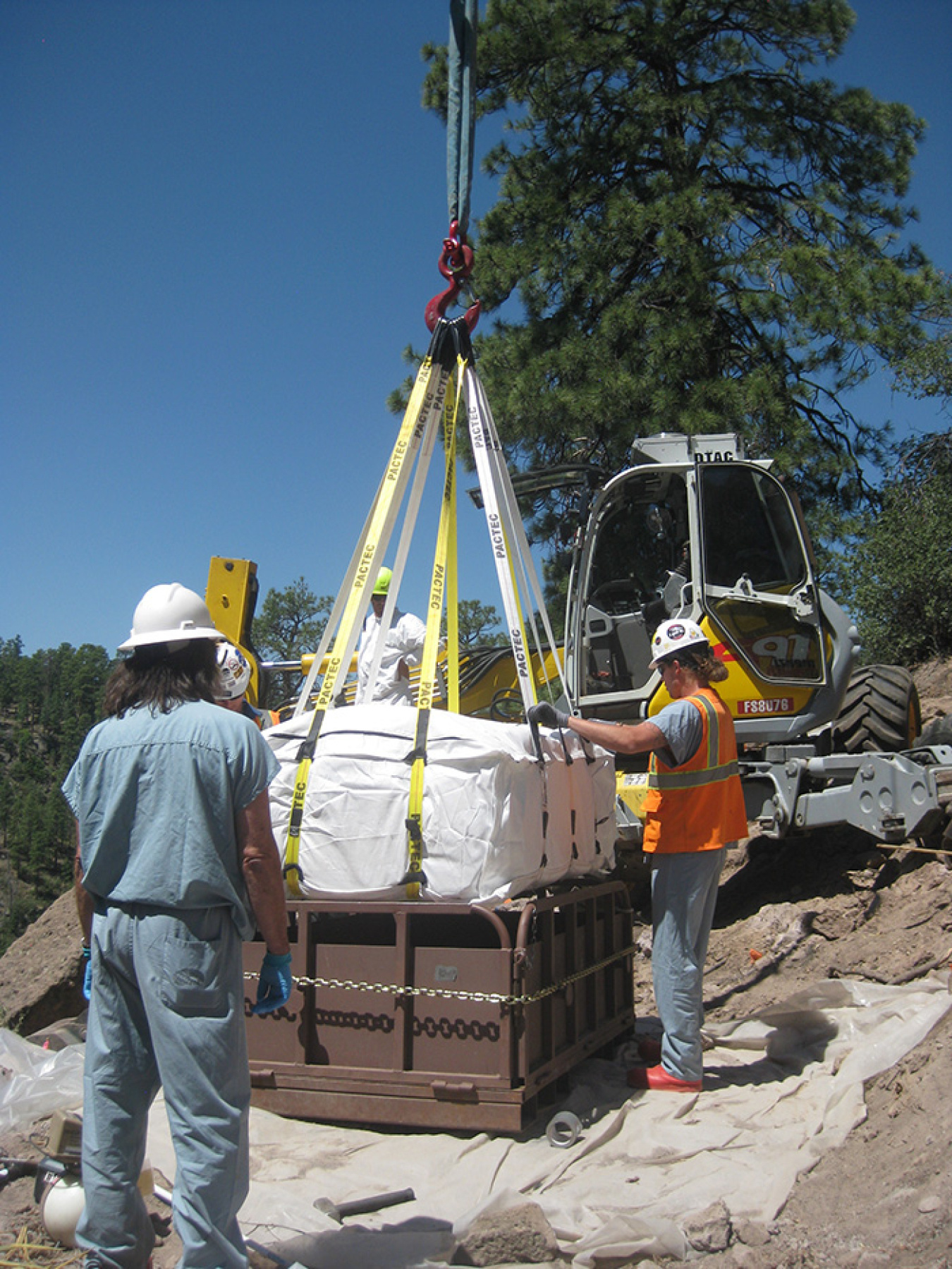 Workers place contaminated soil in special bags and seal them prior to transportation.