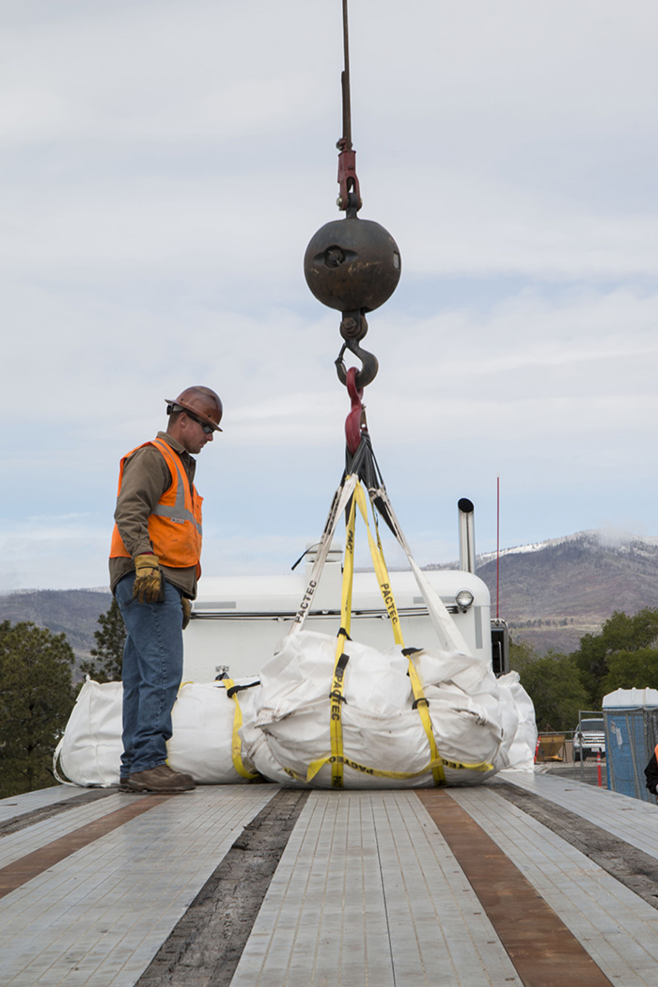 Workers load bags of contaminated soil on trucks for shipment offsite.