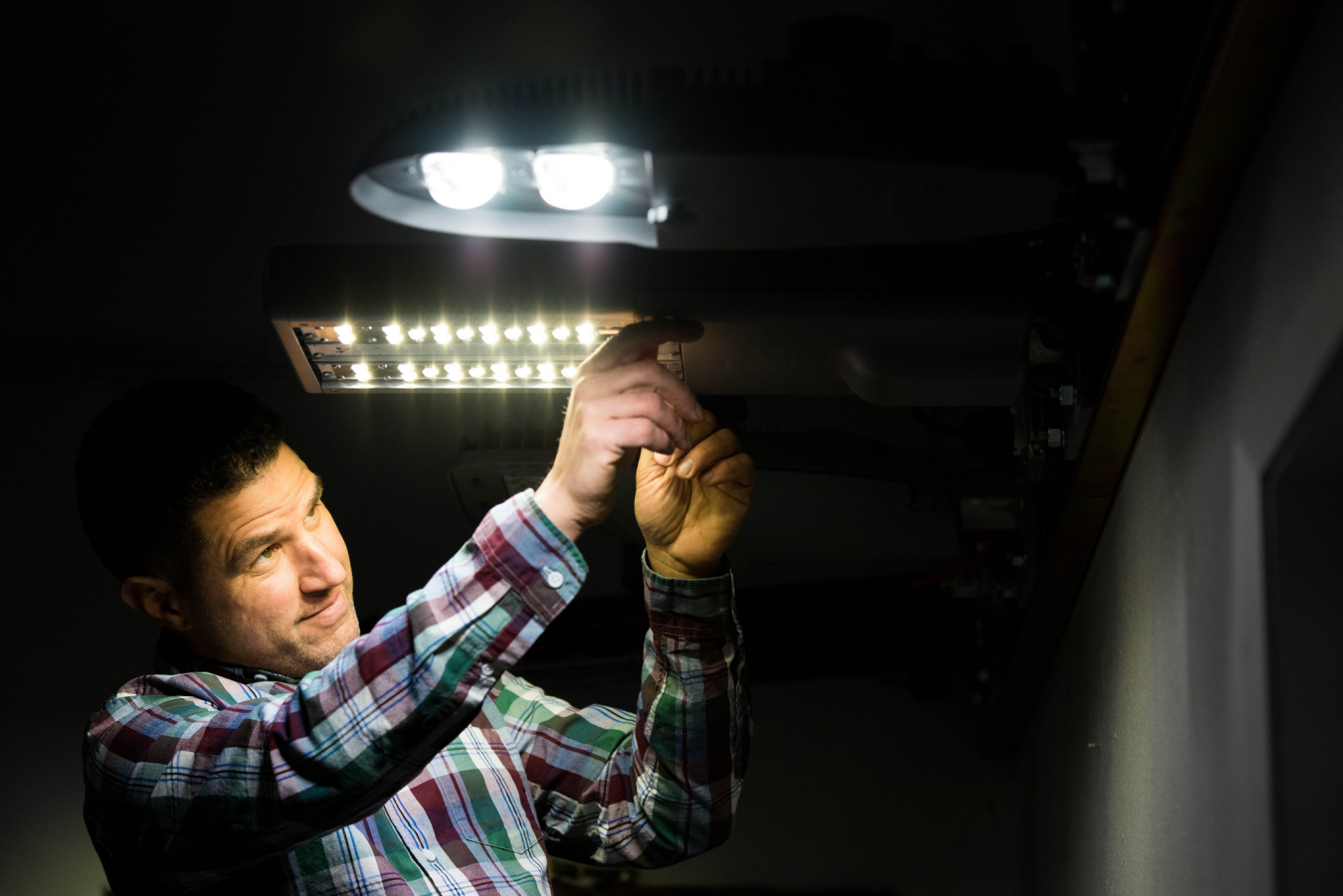 “ The connected lighting test bed is designed and operated by PNNL to characterize the capabilities of market-available connected lighting systems. PNNL lighting engineer Michael Poplawski is shown here with connected outdoor streetlights.