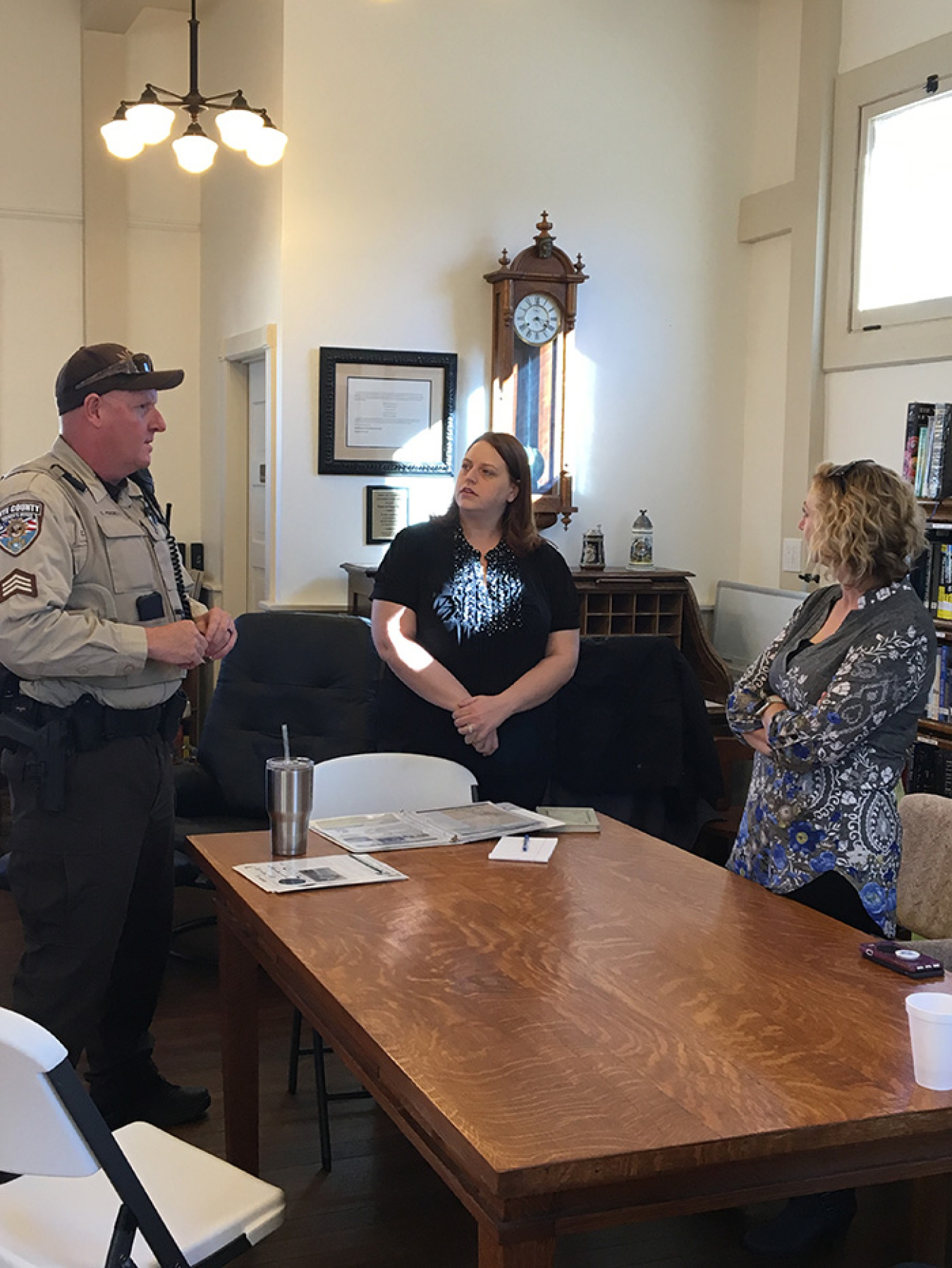 EM Nevada Program Strategic Communications Manager Kelly Snyder (center) and Tiffany Lantow (right), the program’s long-term monitoring lead, talk with a Nye County deputy at the historic Tonopah Library.