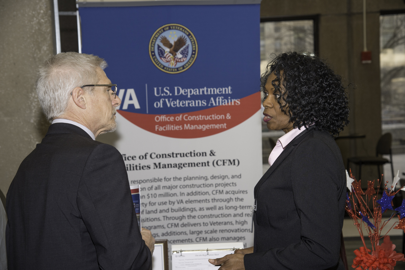 A visitor speaks with the VA at their booth.