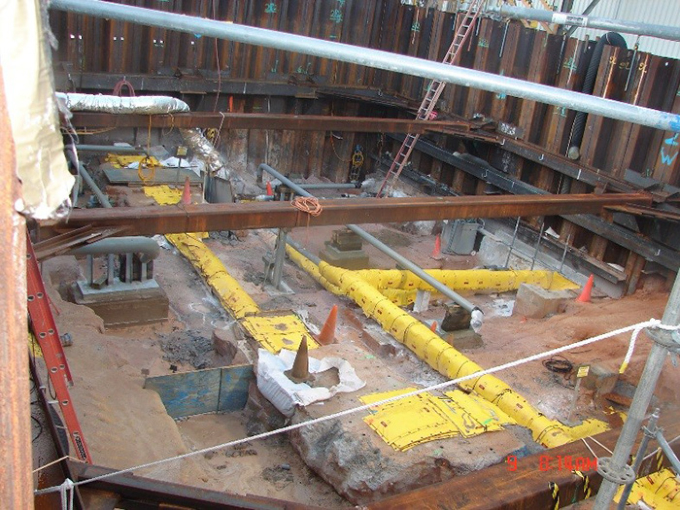 Workers place new strip effluent line on the permanent supports in the 511-S excavation.