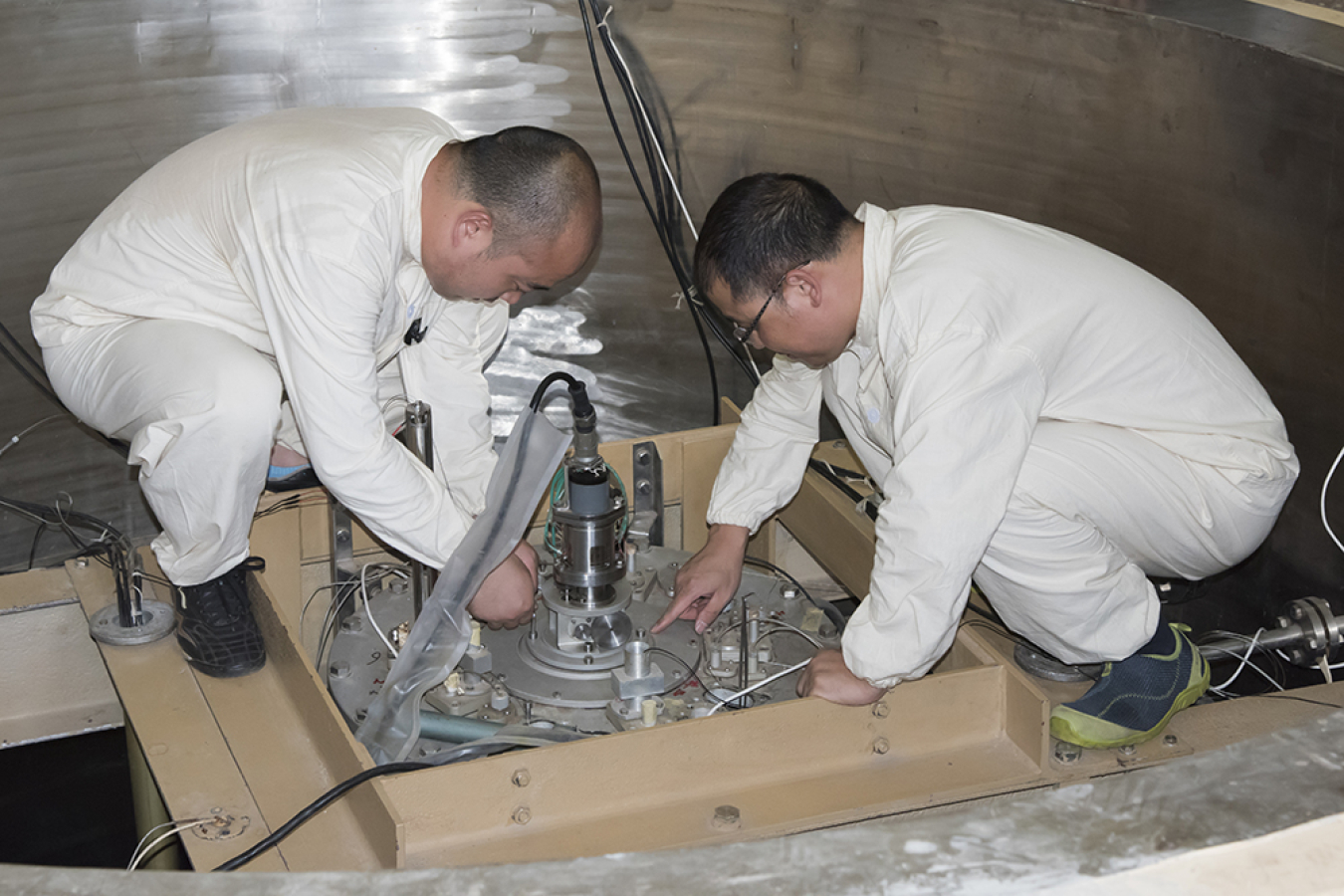 Members of the technical team make adjustments during a reactor conversion in Ghana