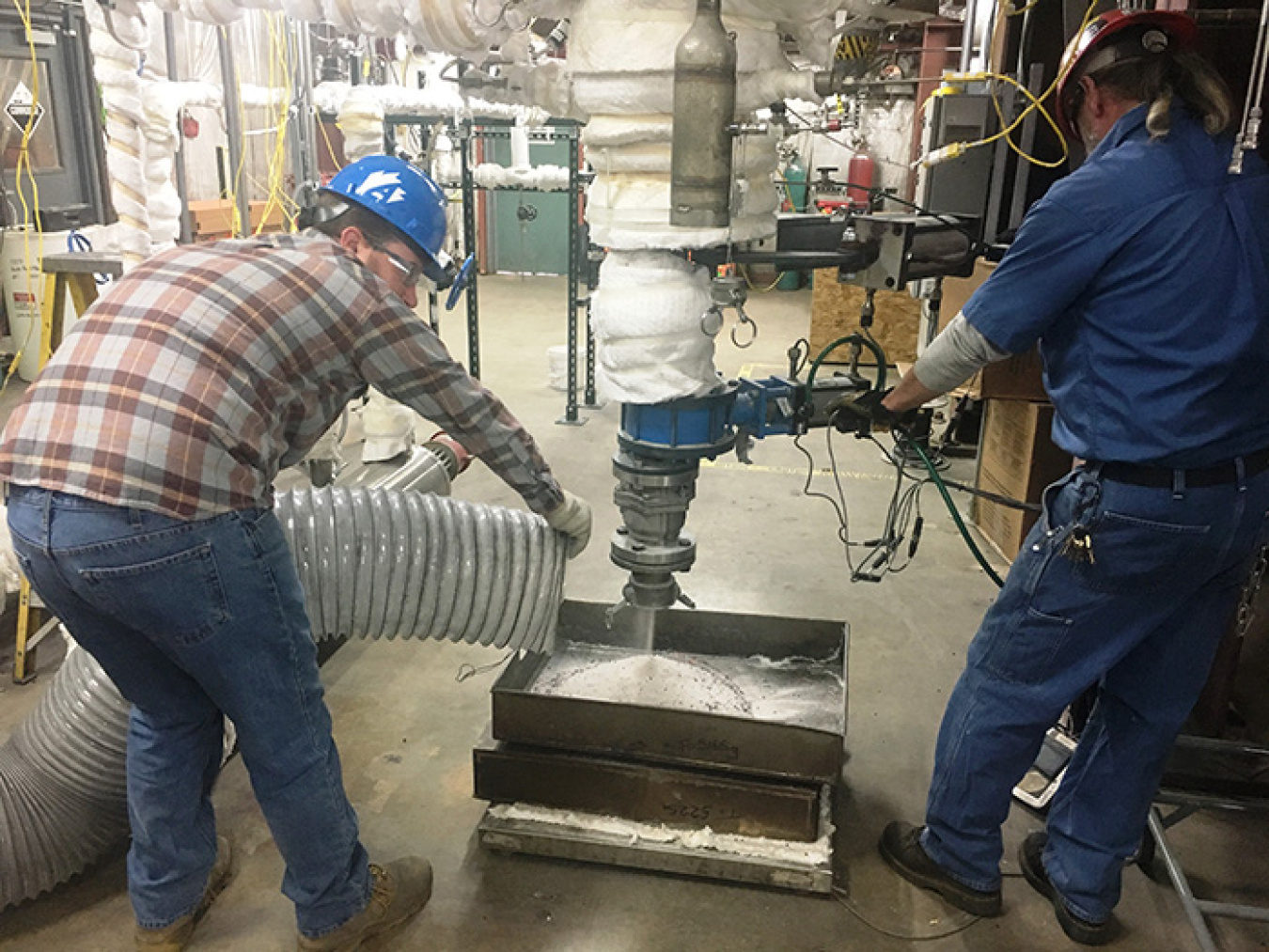 Hazen Research staff remove simulant product from the Denitration Mineralization Reformer.