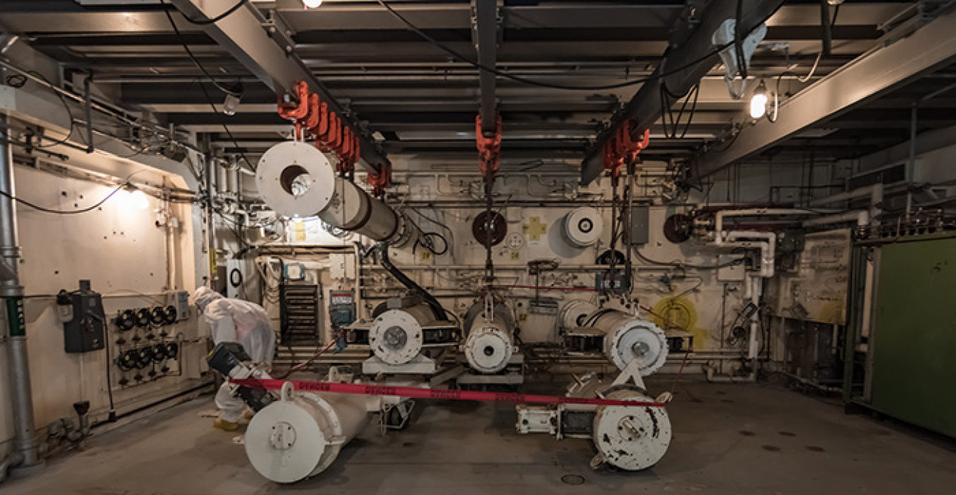 A worker looks at reactor components that were once part of an experimental laboratory area. By entering the K East Reactor now, workers can help a planning team understand current conditions and establish future safety controls and work processes.