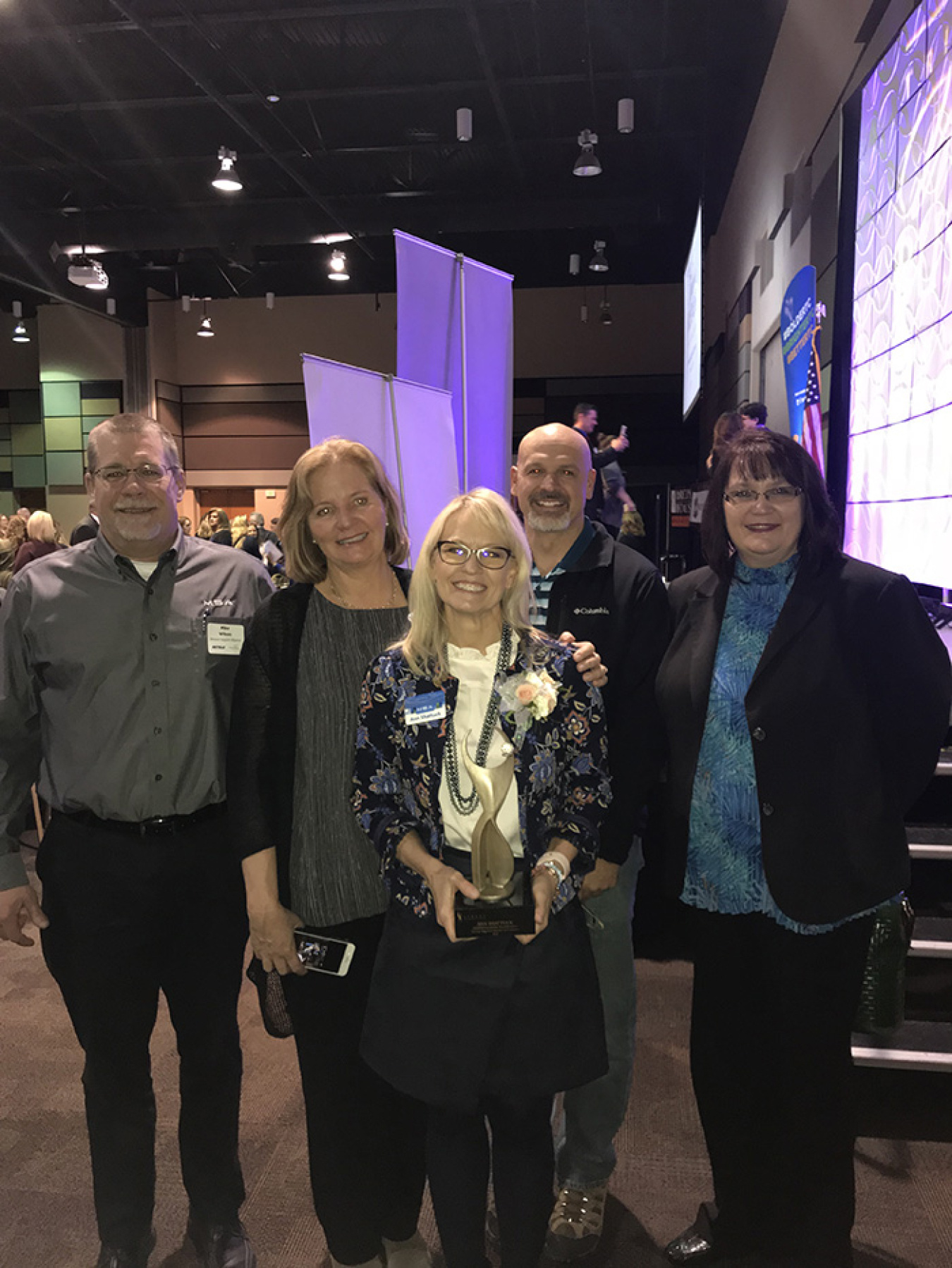 (Left to right) Mission Support Alliance employees Mike Wilson, Dru Butler, Bob Wilkinson, and Amy Basche congratulate Ann Shattuck (front) on her award during the Tri-City Regional Chamber of Commerce 2018 Women in Business conference.