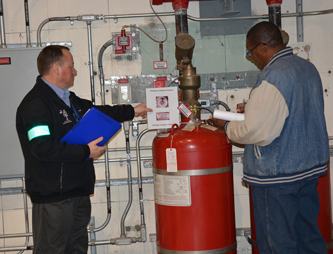 Eric Bell (left) of Operations Support observes Facility Operator Charles Ray during a scenario-based training drill.