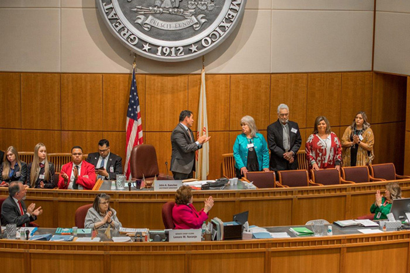 NM Lt. Gov. John Sanchez leads a round of applause for Rose Scott, who was in the NM State Senate Chamber with her family to be recognized for her involvement in NM politics for more than 35 years, including more than 19 years at the WIPP.