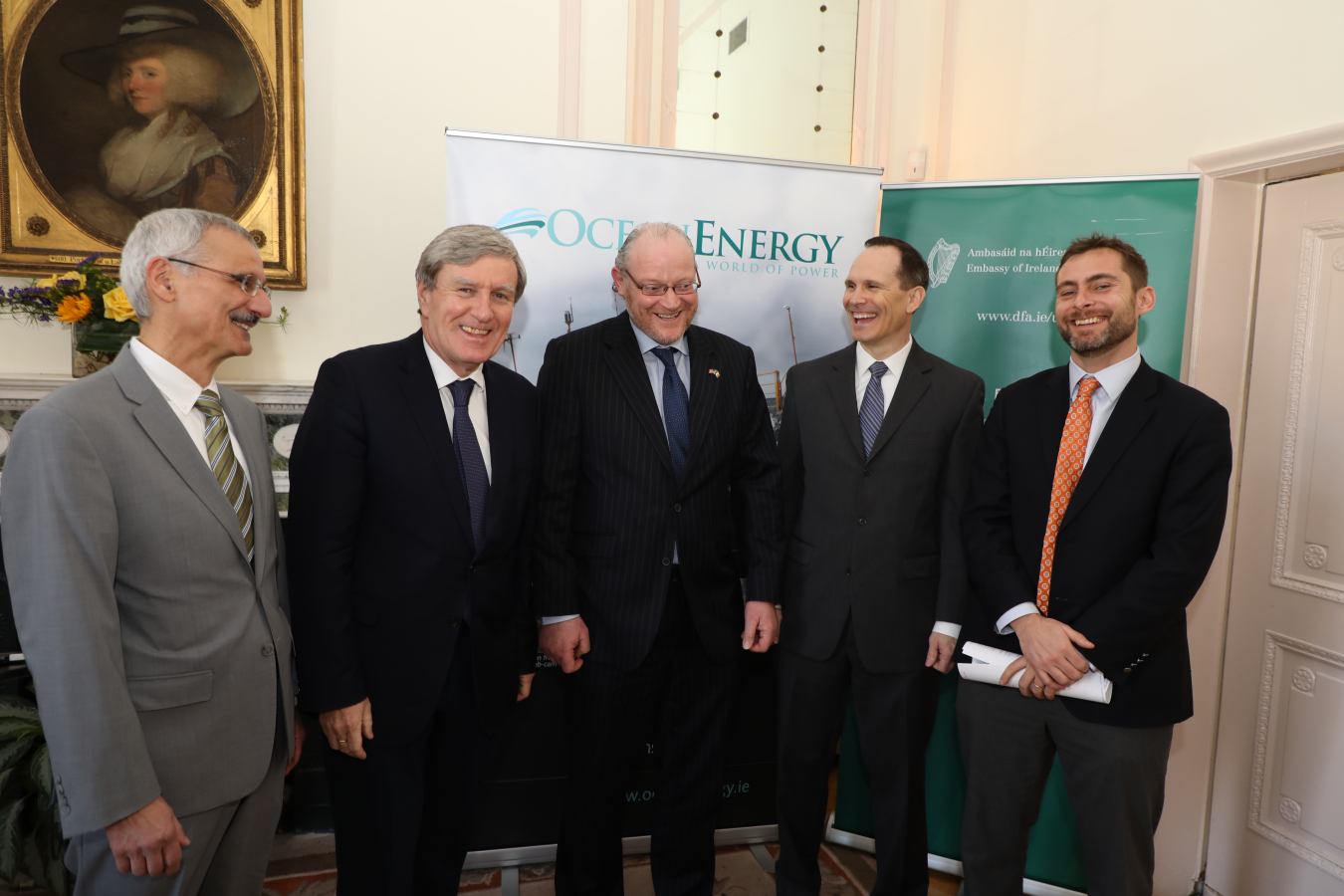 Five men standing in front of an Ocean Energy Systems banner