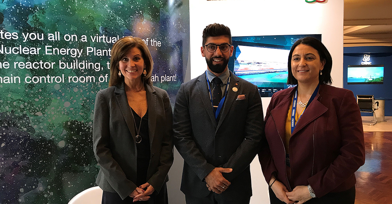Two DOE officials pose with a representative of the Emirates Nuclear Energy Corporation.