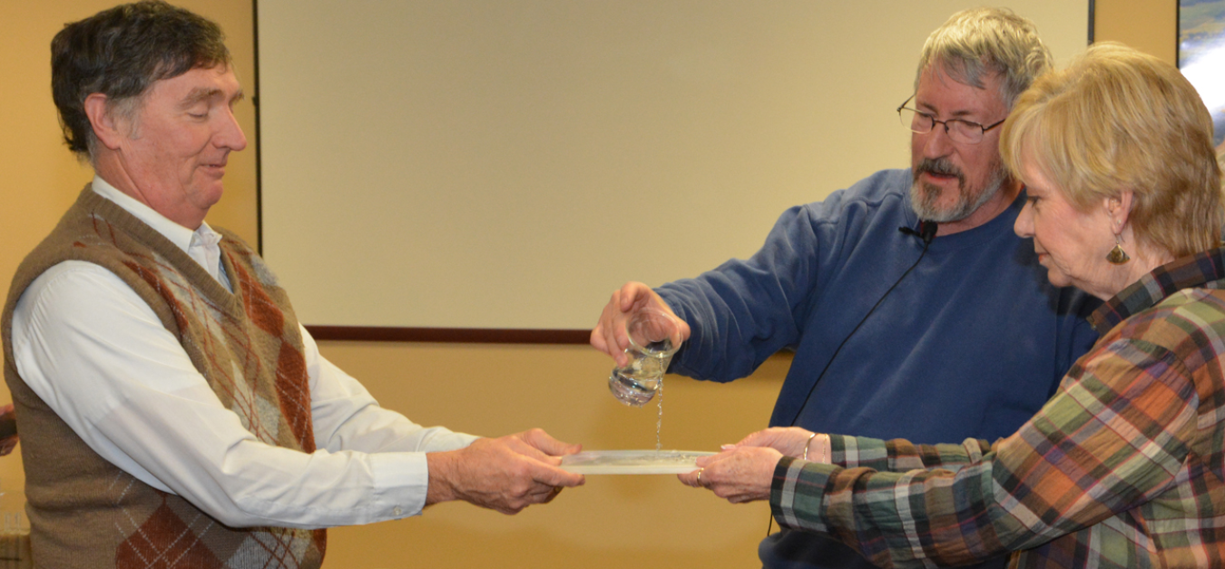 Dr. Mike Kemp (center) demonstrates variables affecting water flow with different types of soil, with Renie Barger (right) and Dr. Bill Murphy.