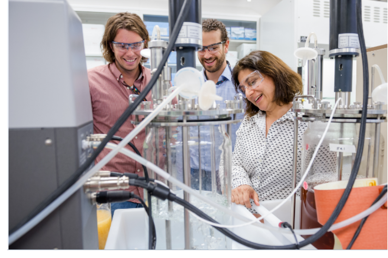 Two men and one woman conducting research in a scientist lab.
