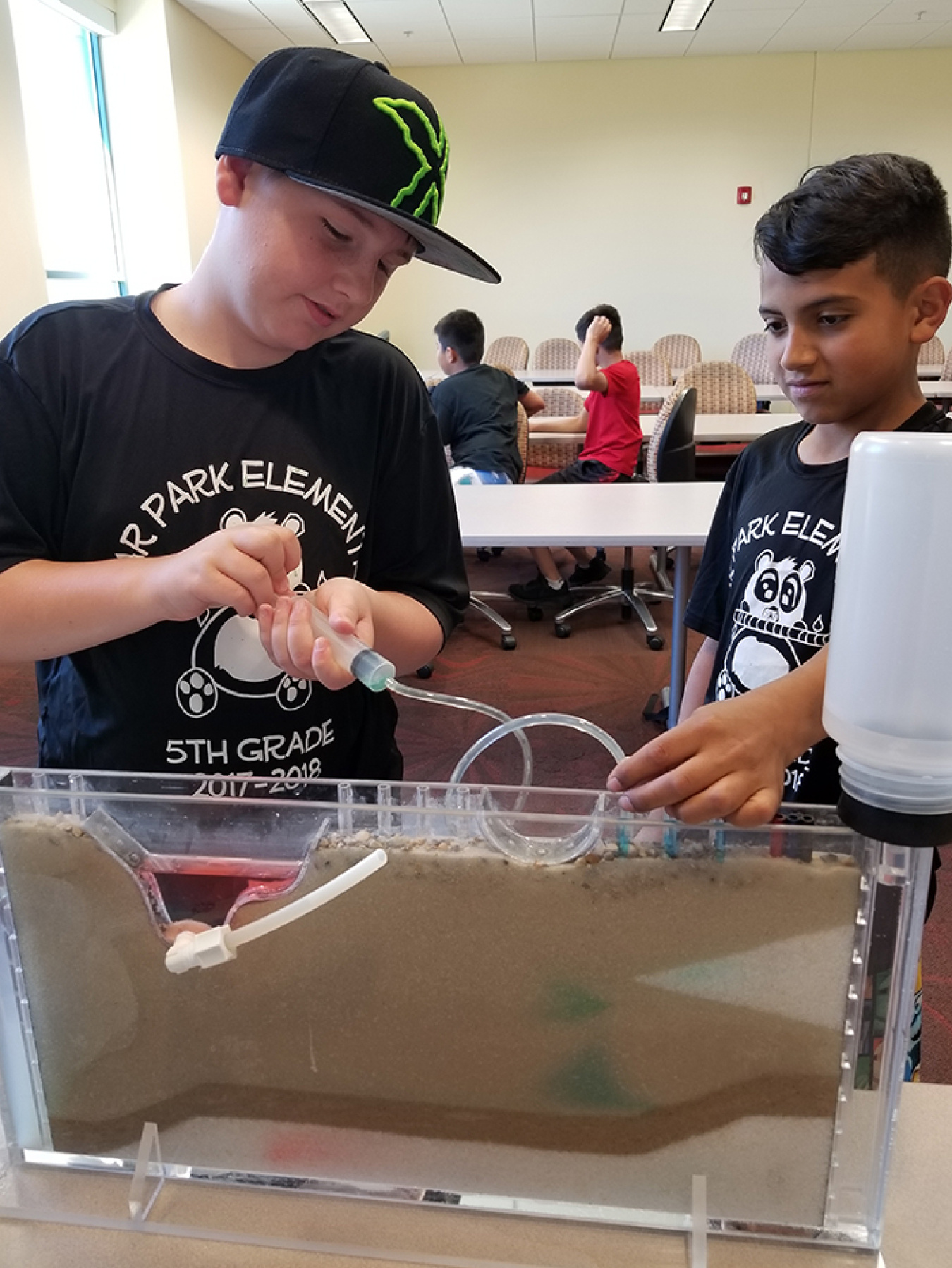 Fifth-graders from the Grand Junction, Colorado area worked on sand-tank models to remove simulated groundwater contamination.