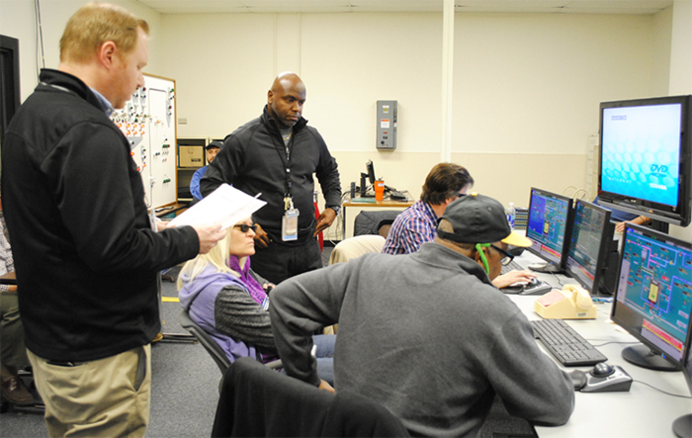 Tim Turner, center, Saltstone Shift Operations Manager, and Russ Webb, left, Saltstone Simulator Instructor, provide instruction and oversight to control room operators. SRR disposes low-activity waste into a grout form in the site’s Saltstone Production