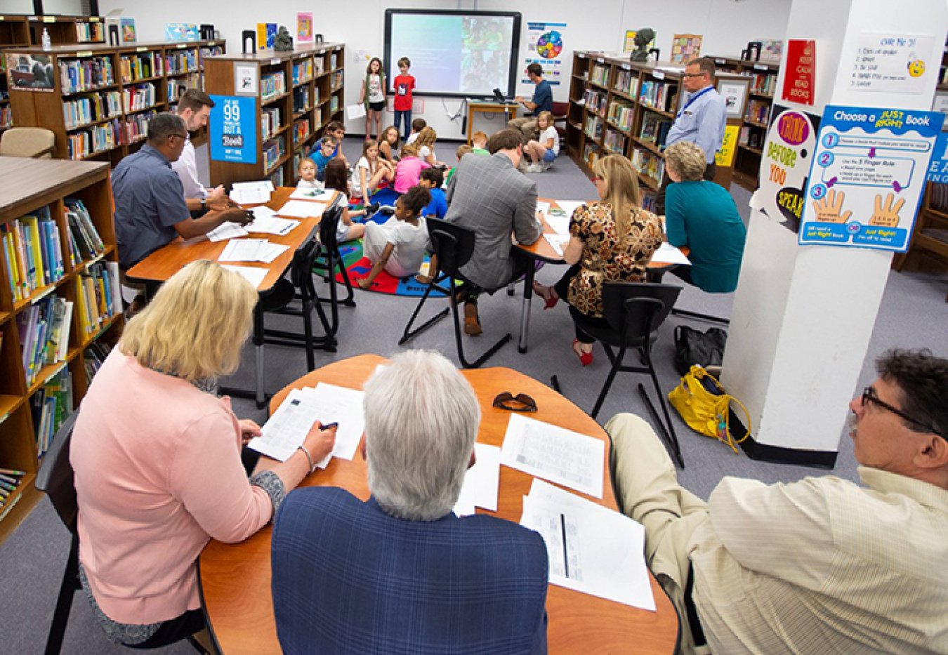 Oak Ridge Office of Environmental Management employees listen and give tips to third-graders presenting their “Schools around the World” project.