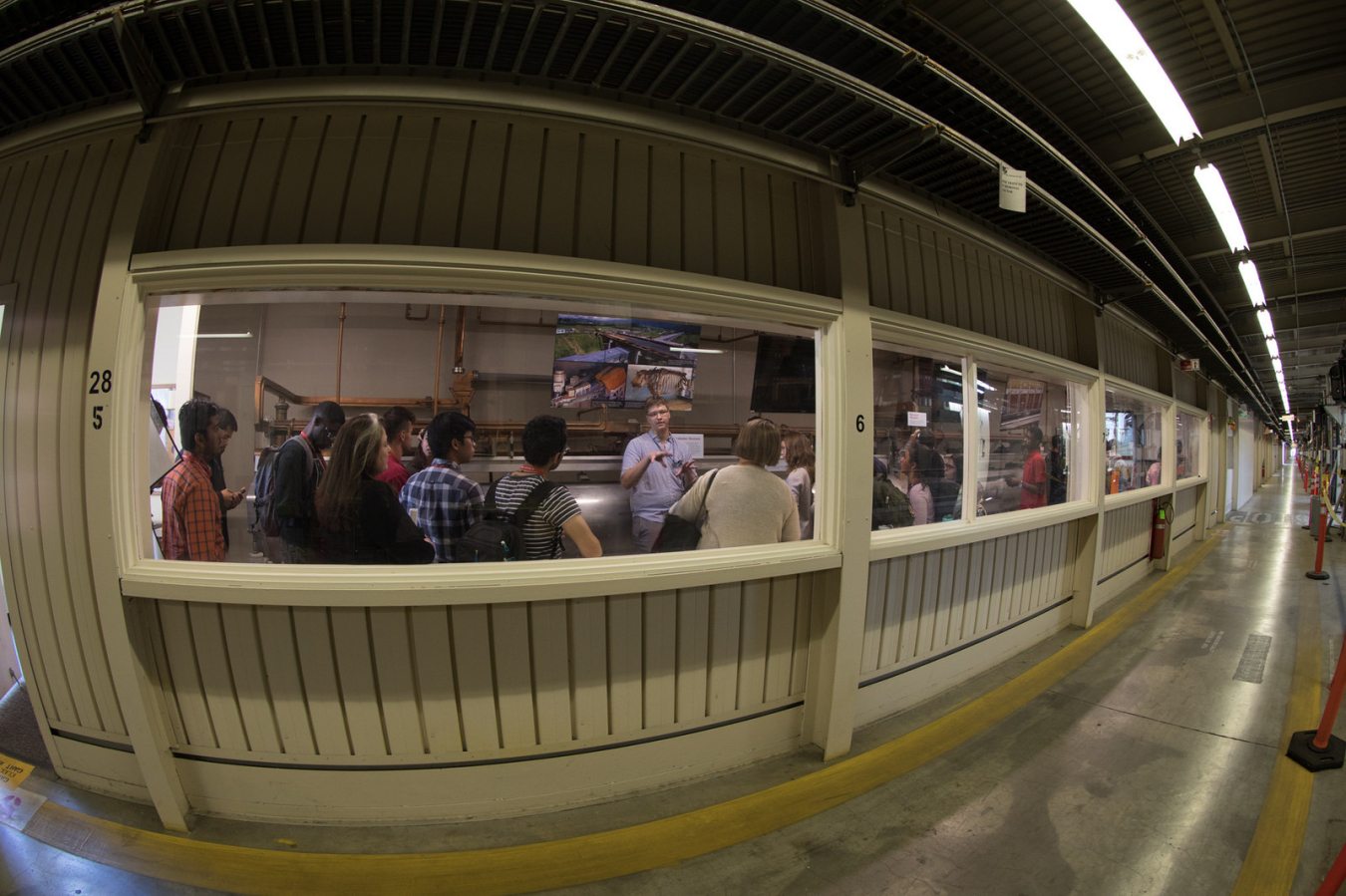Matt Ware, a PhD student from the Stanford PULSE Institute at SLAC, leads a tour of the Klystron Gallery for incoming Stanford graduate and professional school students interested in energy.