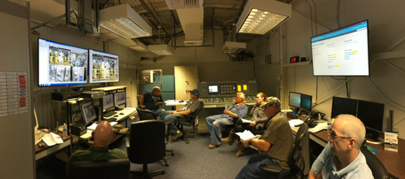 Workers in the control room monitor the beginning of transferring sludge out of the K West Basin on the Hanford Site.