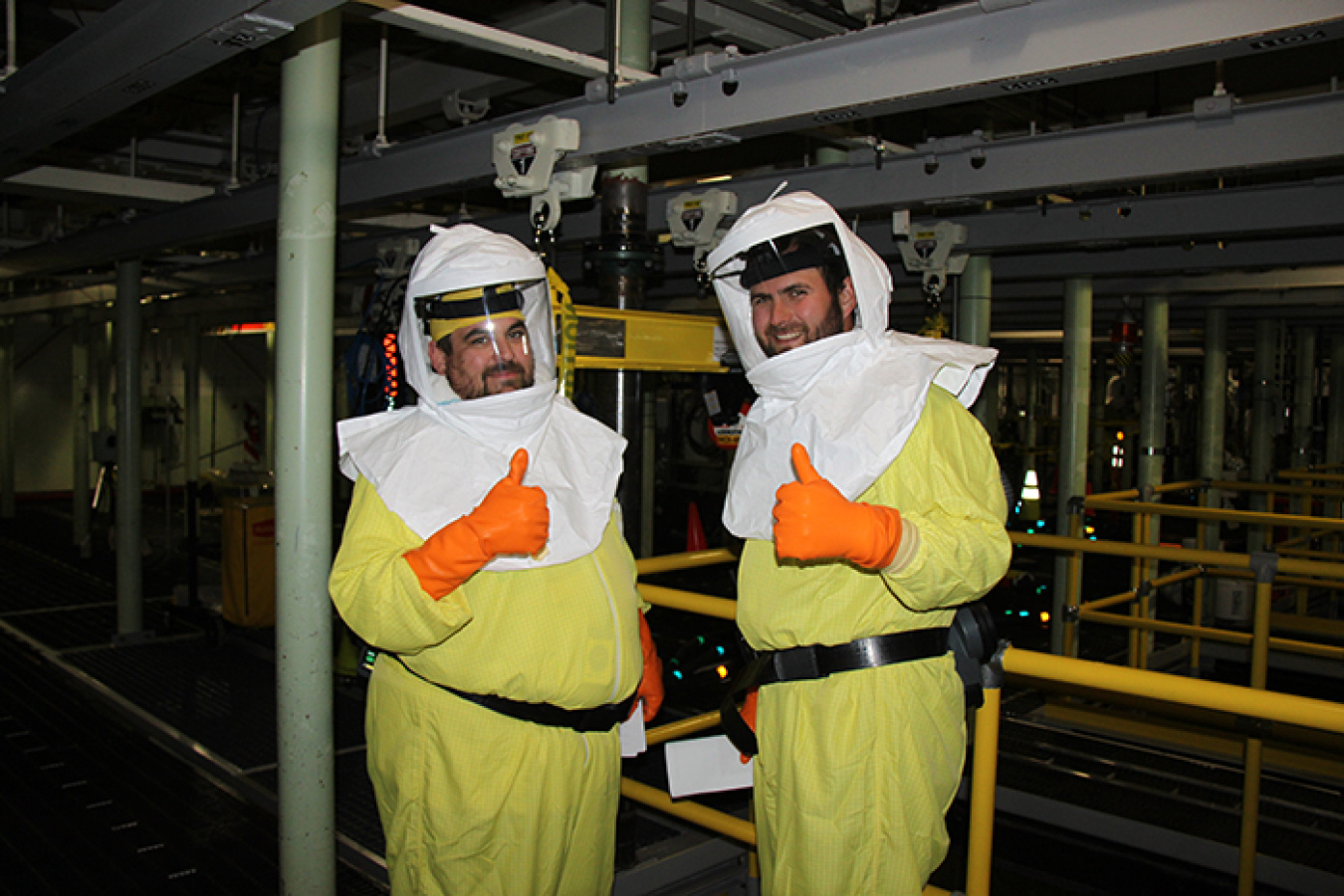 Shay DeWitt, nuclear chemical operator, left, and Mike Garza, field work supervisor, give a thumbs-up during the first day of sludge retrieval on June 12.