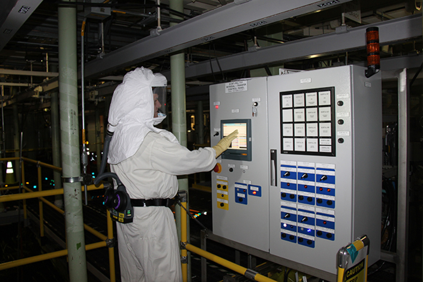 A worker inside the 105-K West Reactor Basin operates a sludge removal equipment control panel during the transfer of the mixture out of the basin.