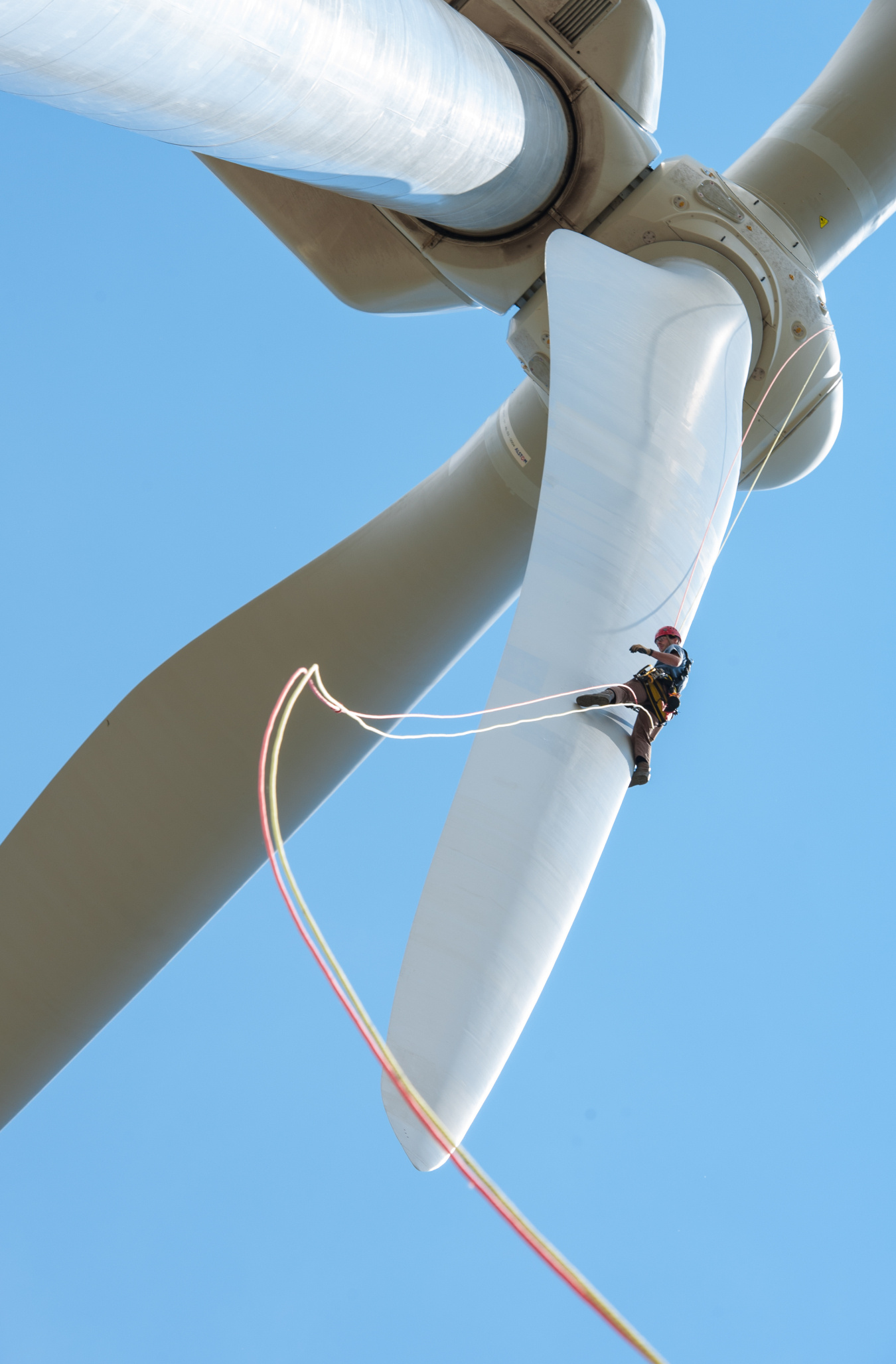 Photo of a man climbing a wind turbine.