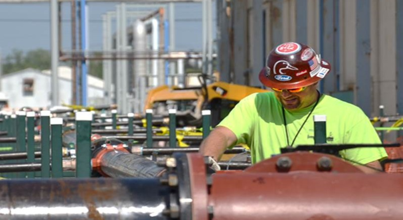 A worker with LATA-Kentucky, predecessor to FFS and FRNP, works on pipes leading to an above-ground treatment system that was part of an electrical-resistance-heating groundwater source remediation project adjacent to the C-400 building.