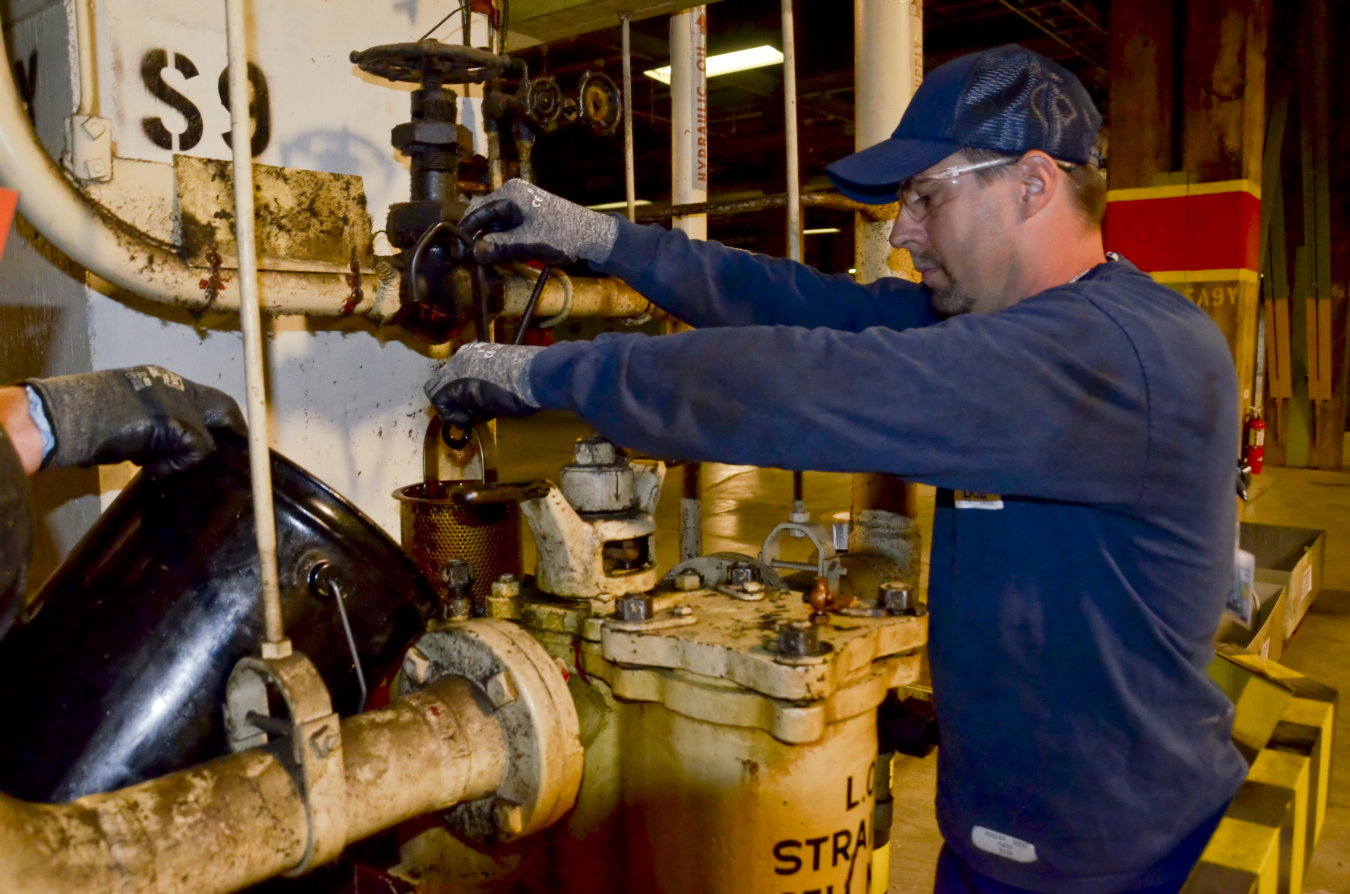 An operator removes a filter in a trap during lubrication oil removal from the process buildings.