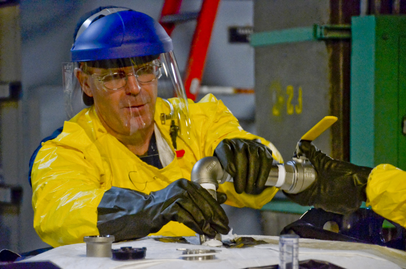 Deactivation crews pump PCB oil from 69 electrical transformers into barrels and totes for disposition.