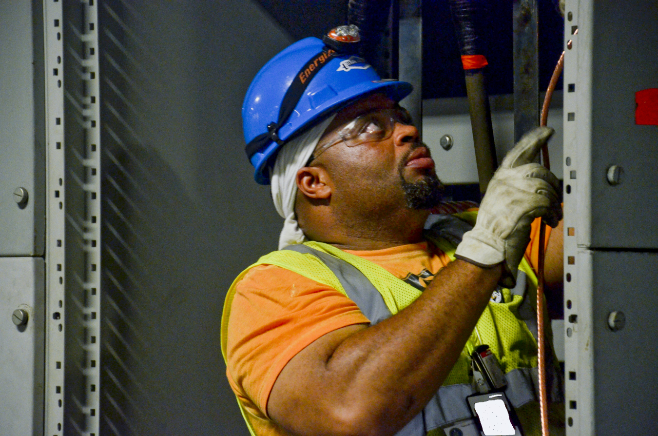 An electrician feeds new wire during the consolidation of the site’s switchyards.