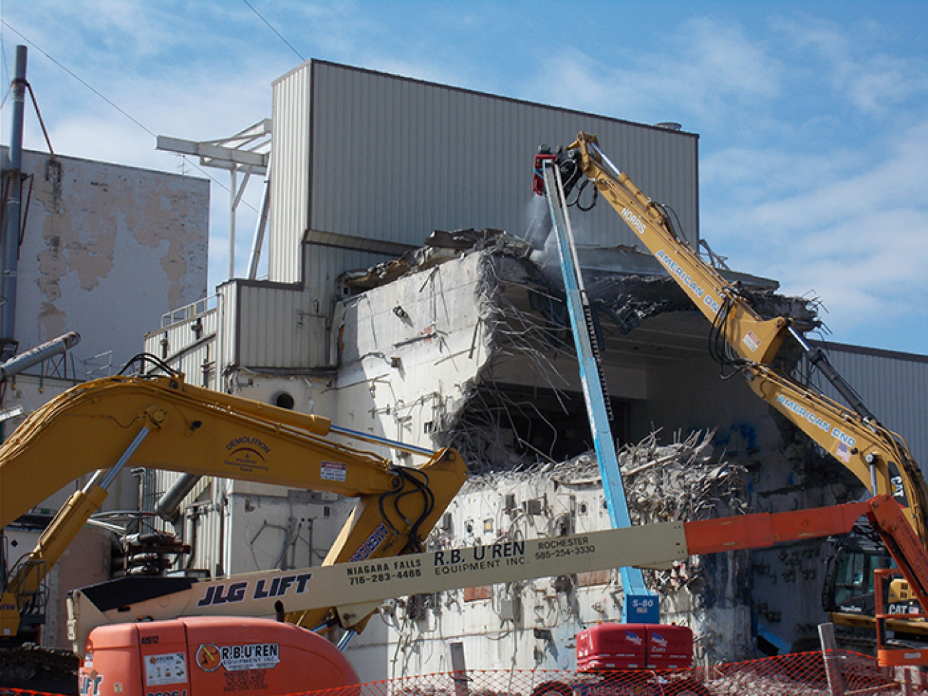 Workers tear down a portion of the Vitrification Facility containing a process cell.