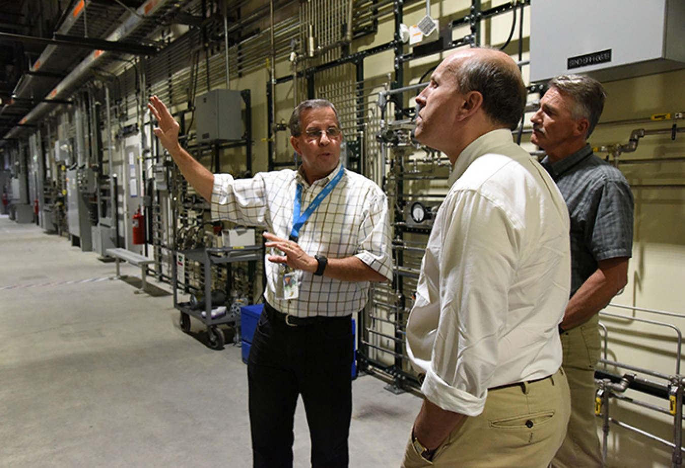 Fluor-Idaho Integrated Waste Treatment Unit (IWTU) Operations Manager Craig Olson, left, and DOE IWTU Project Manager Kevin O’Neill, behind, brief DOE Under Secretary for Science Paul Dabbar at IWTU.