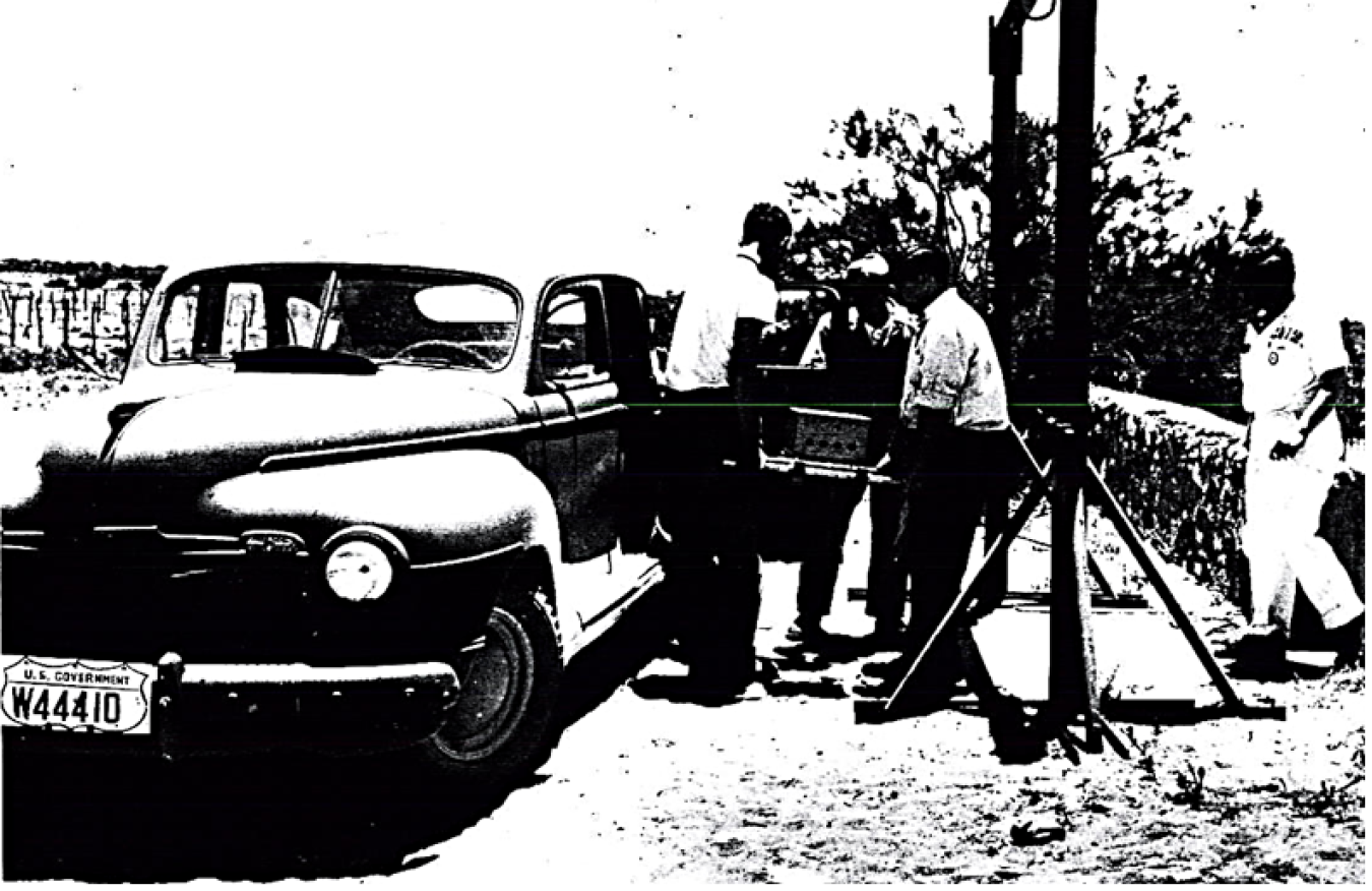 Technical and military couriers from Los Alamos unload a major component of the first atomic bomb from an Army sedan used in 1945 to transport the weapon part to Trinity Site in New Mexico.