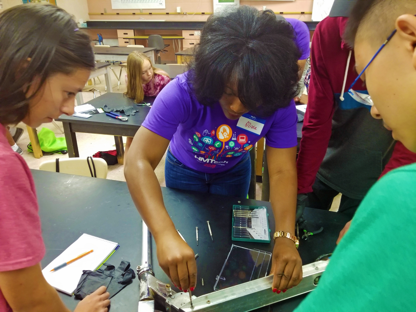 Sandia National Laboratories materials scientist Olivia Underwood helps students disassemble a scooter during her materials science class. This is the first year she has served as a HMTech instructor