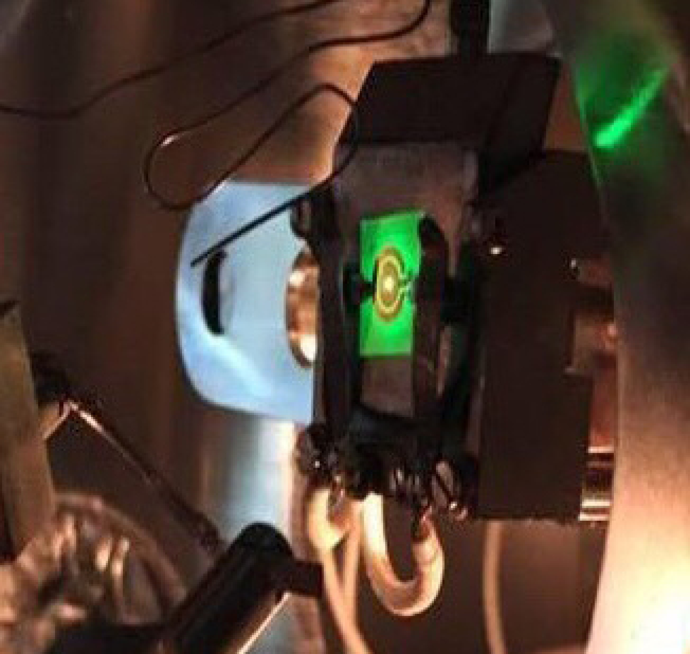 A green LED being electrically powered inside an ultra-high vacuum electron emission spectroscopy chamber.
