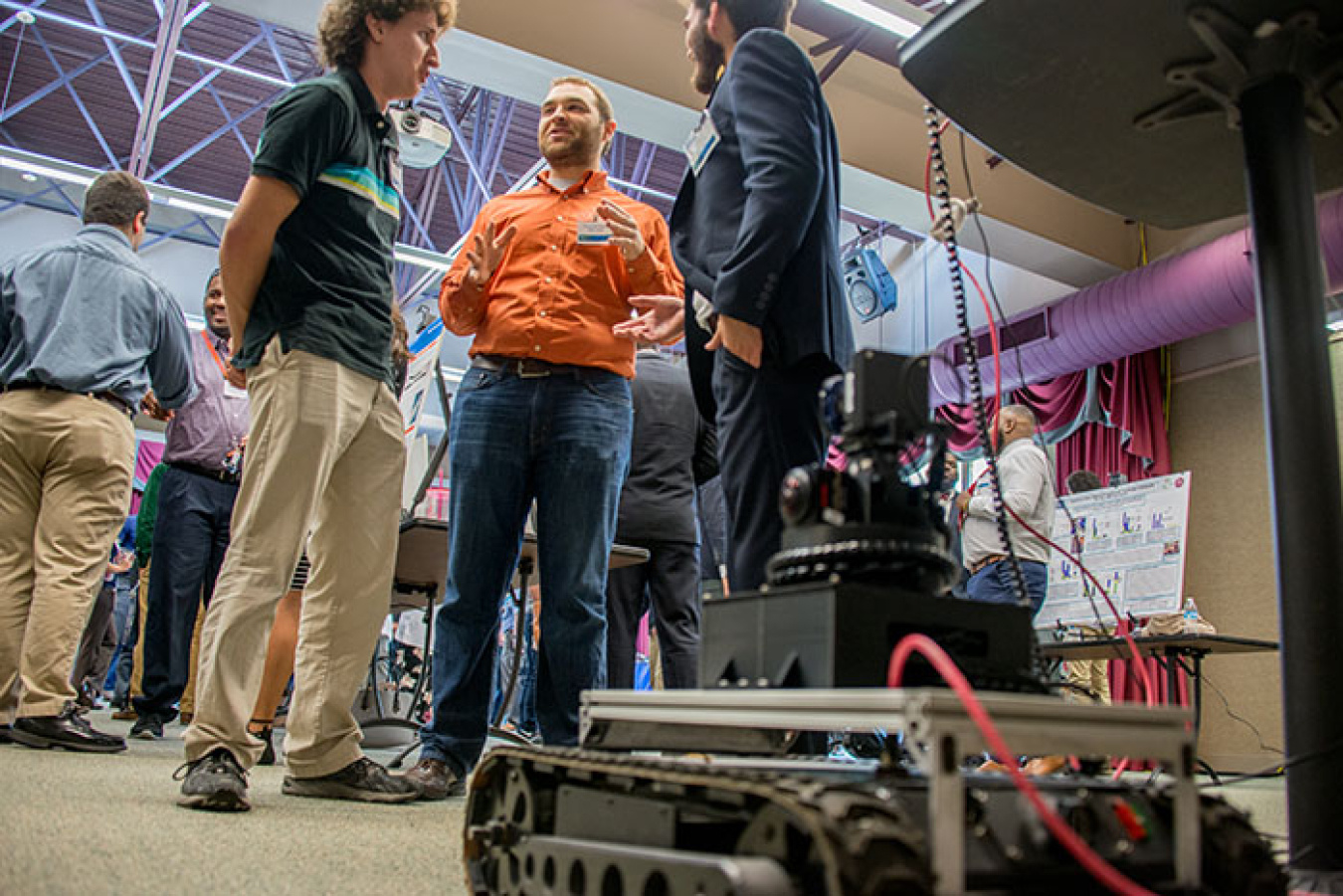 Left to right, University of Texas at Austin mechanical engineering students Connor McMahon and Chris Suarez discuss robotics with Florida International University electrical engineering major Manuel Losada.