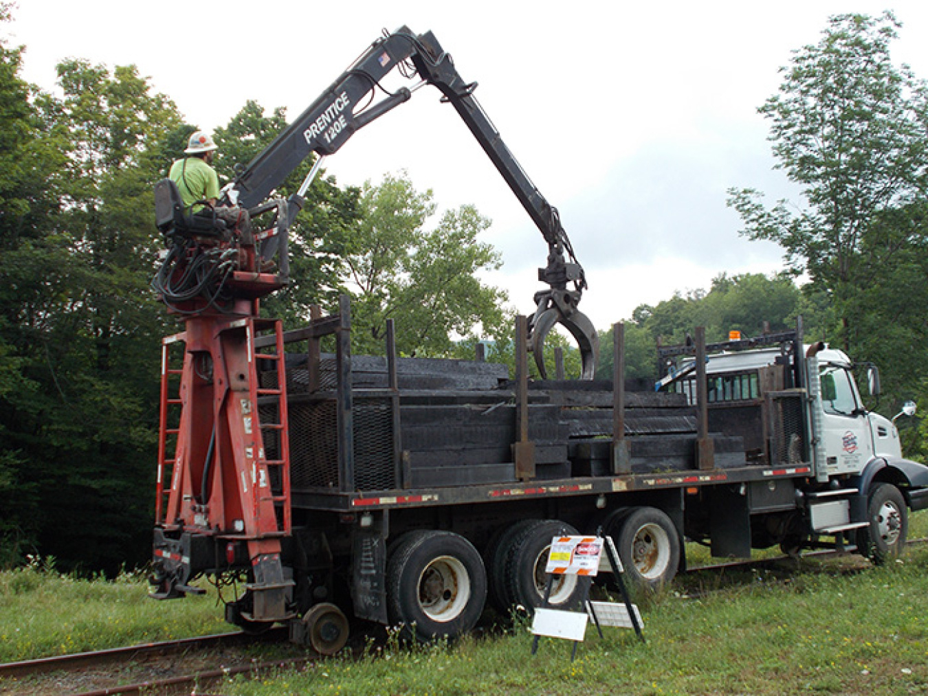 A railroad worker uses a truck-mounted crane to safely place new rail ties along the West Valley Demonstration Project site rail spur tracks to prepare for repairs and straightening.