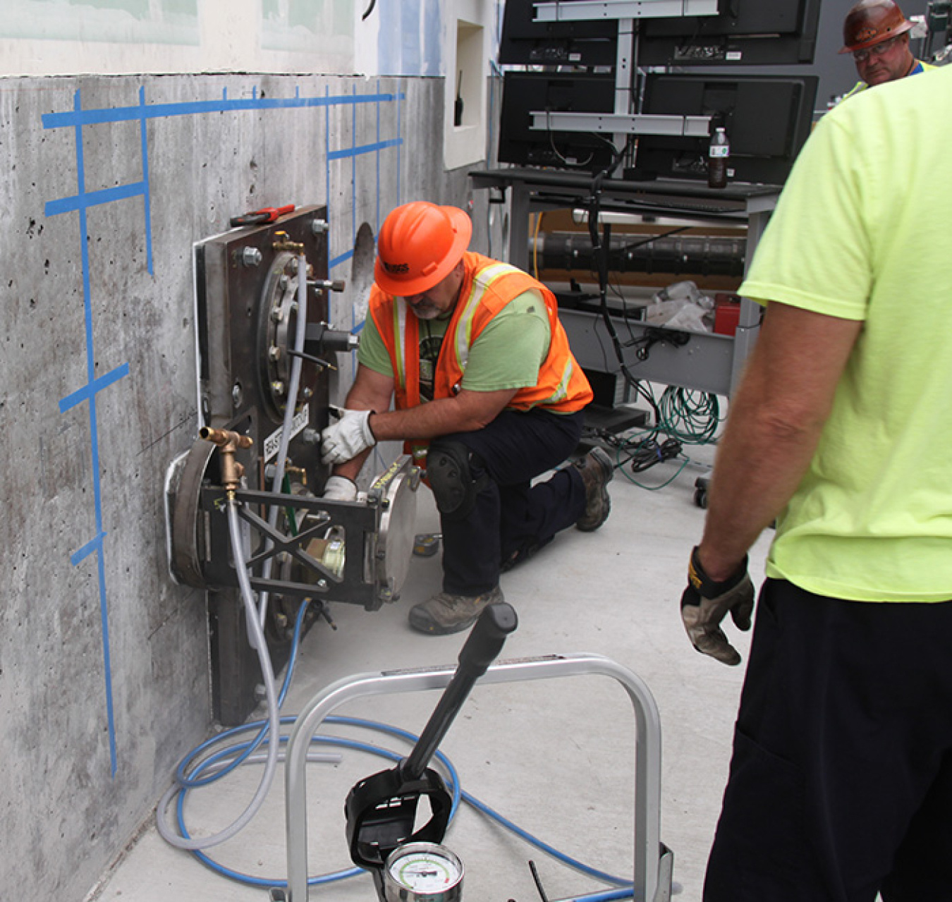 Workers at the 324 Building mockup install a remotely operated excavator for training purposes. The tool replicates the equipment that will remove part of the 324 Building’s floor and the highly radioactive soil beneath.