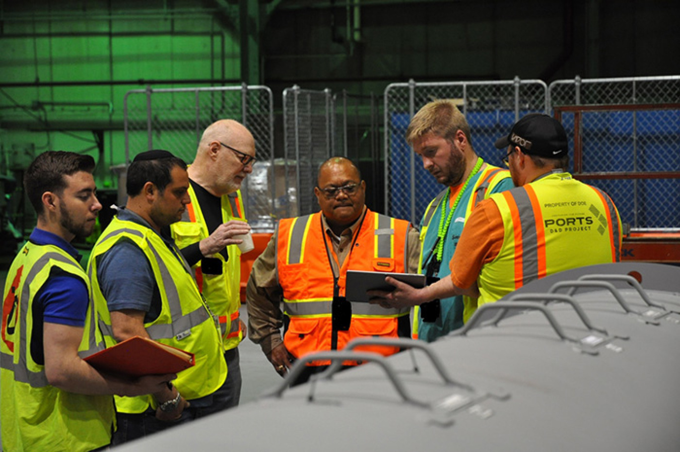 FBP's Rob Allyn demonstrates how to use a tablet to launch the Radpiper robot. From left, EM Fellow Michael DiBono; CMU’s David Kohanbash and William “Red” Whittaker; Rod Rimando, Dir of EM’s Tech Dev Office; and FBP's Allyn and Brian Summers.