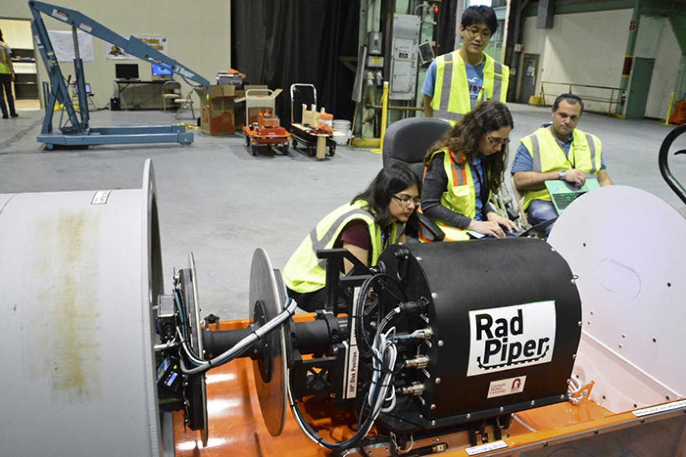 Carnegie Mellon University (CMU) roboticists make adjustments to the program to move the robot. From left, Siri Maley, Heather Jones, Kenji Yonekawa, and David Kohanbash.