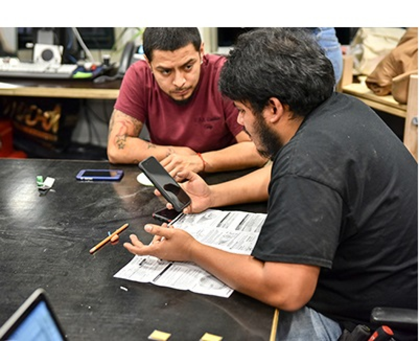 Photo of two men looking at a cell phone. 