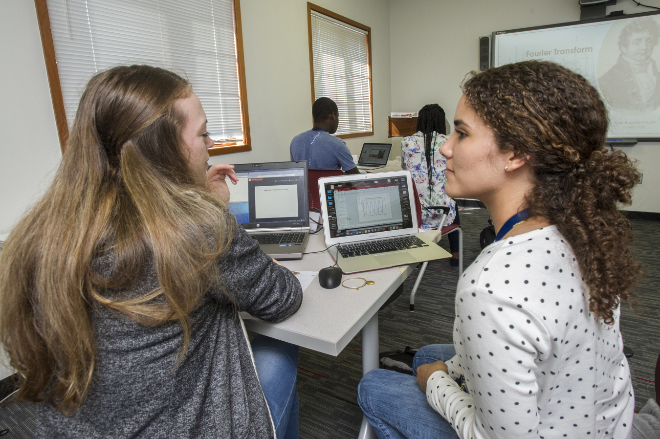 Alyssa Blanton (left) of the University of Texas and Coral Salort of the University of Puerto Rico, Rio Piedras Campus collaborate on a computational physics problem in which they model the decay of radioactive medical tracers.